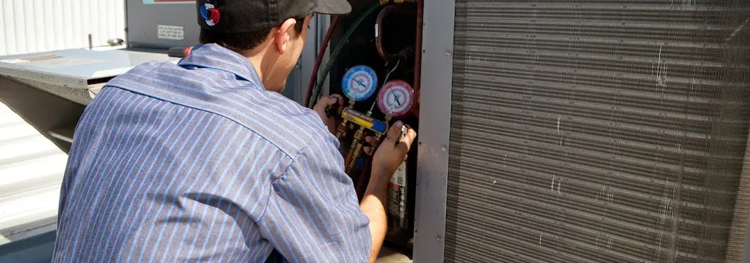 HVAC technician servicing a condenser unit in Salisbury